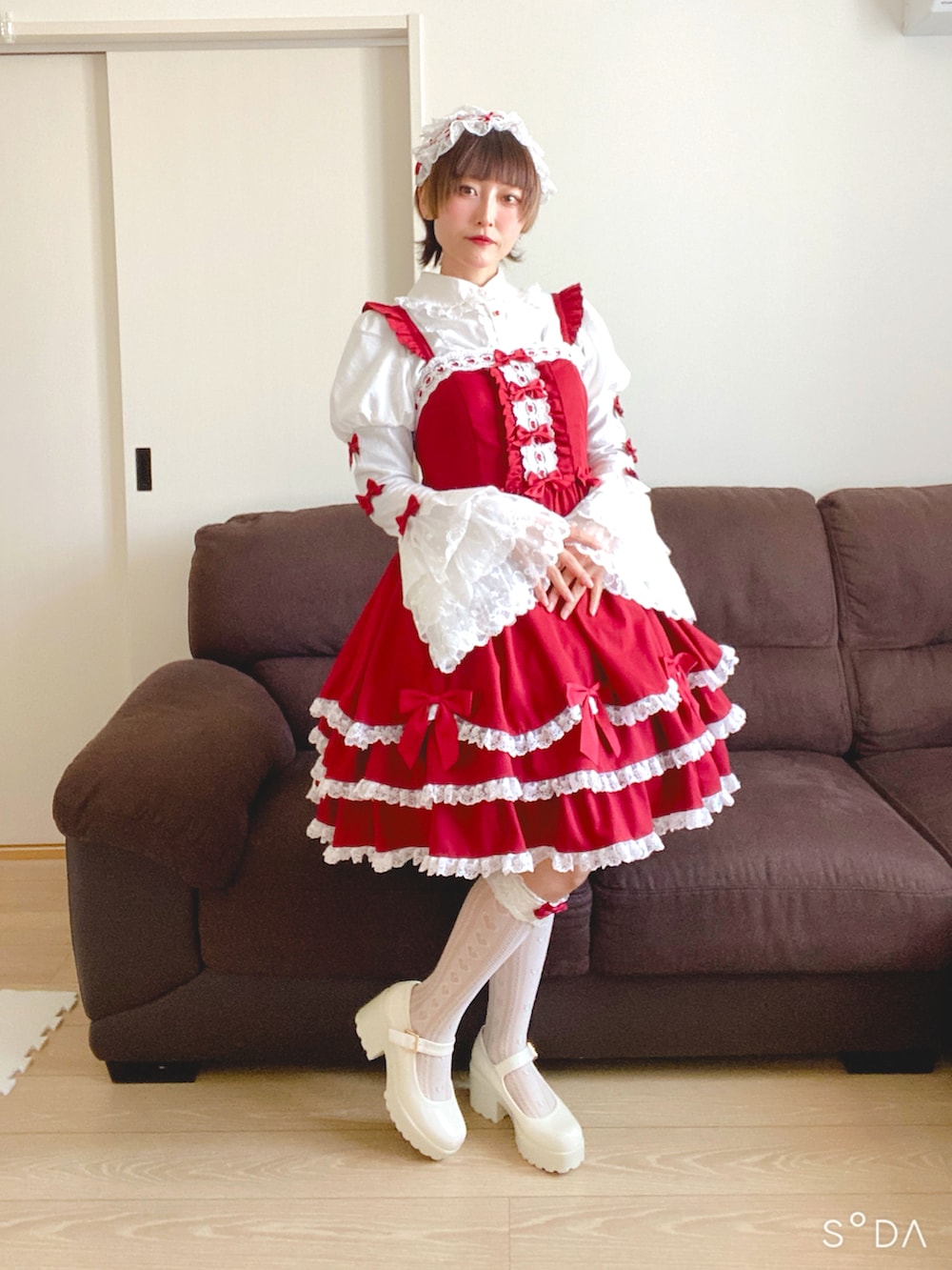 ホワイト系のパンプス、レッド系のジャンパースカートを着用したレディースの春コーディネートの2枚目の写真