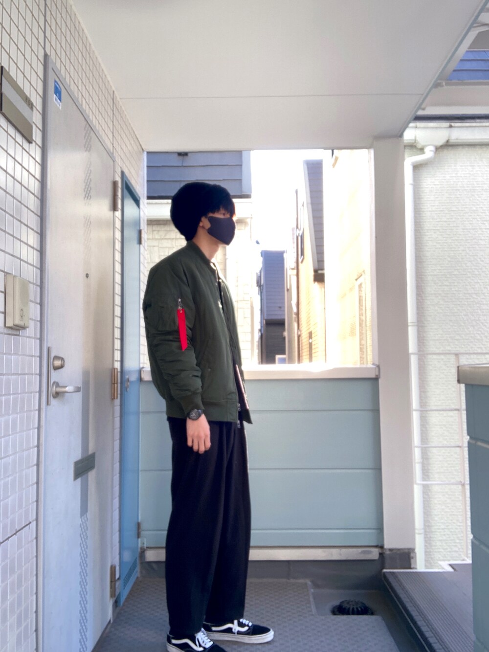 グリーン系のダウンジャケット/コート、ブラック系のその他パンツ、ブラック系のTシャツ/カットソーを着用したメンズの冬コーディネートの2枚目の写真