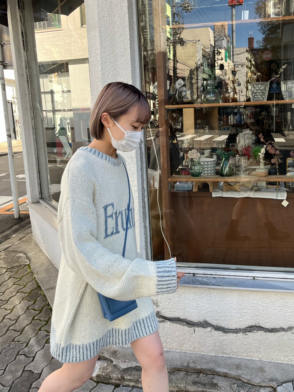 ホワイト系のベスト、ホワイト系のニット/セーター、ブルー系のショルダーバッグを着用したレディースの秋コーディネートの4枚目の写真