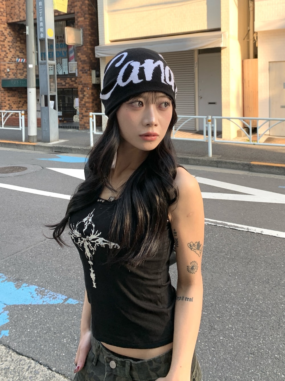 ブラック系のタンクトップ、その他のデニムパンツ、ブラック系のニットキャップ/ビーニーを着用したレディースの冬コーディネートの2枚目の写真
