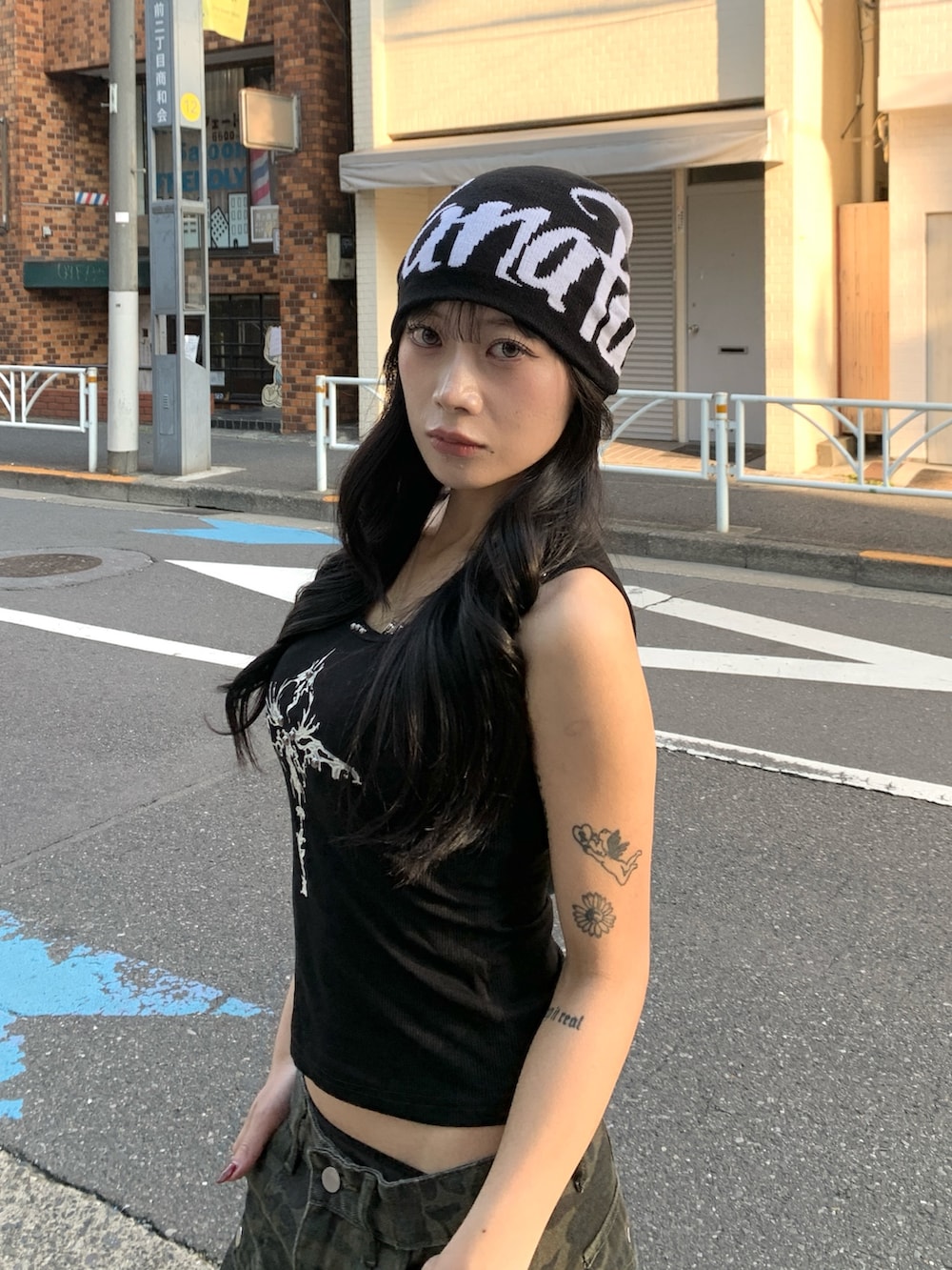 ブラック系のタンクトップ、その他のデニムパンツ、ブラック系のニットキャップ/ビーニーを着用したレディースの冬コーディネートの3枚目の写真