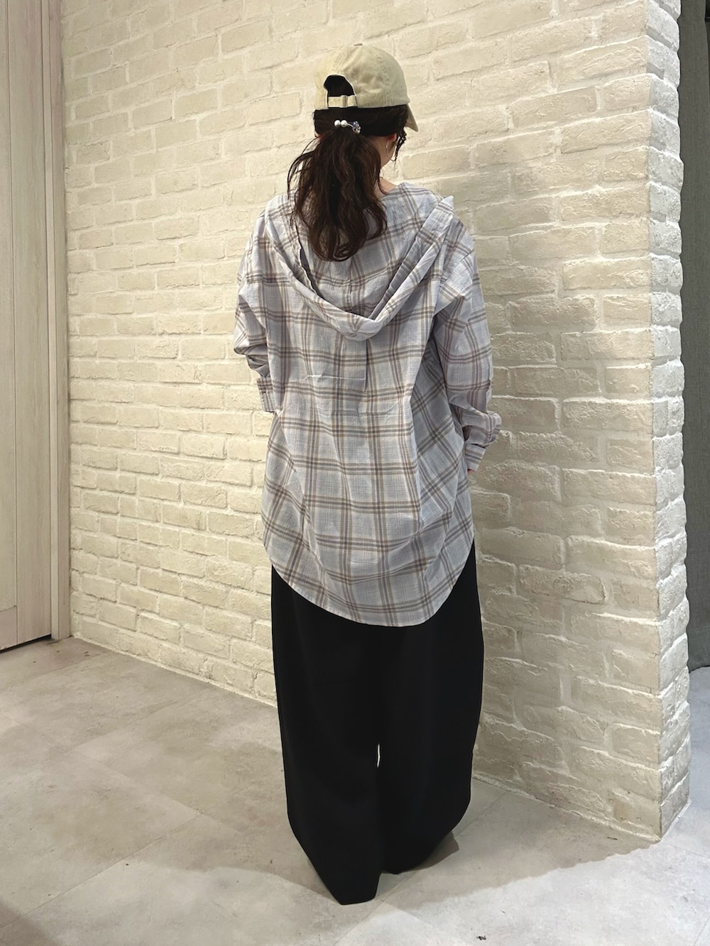 ブルー系のシャツ/ブラウス、ブラック系のスラックス、ホワイト系のトートバッグを着用したレディースの春コーディネートの4枚目の写真