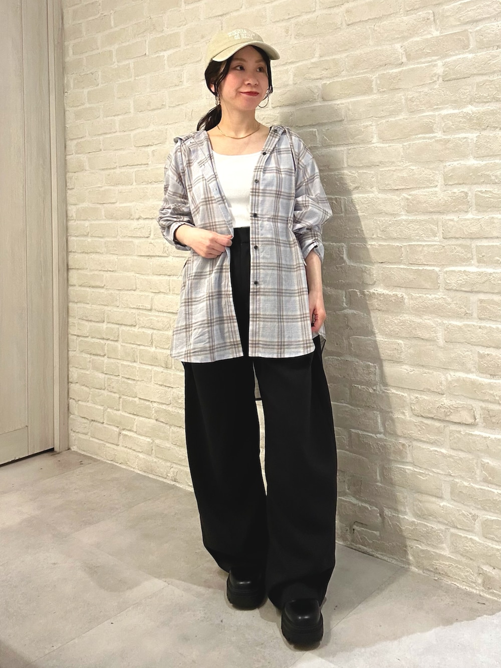 ブルー系のシャツ/ブラウス、ブラック系のスラックス、ホワイト系のトートバッグを着用したレディースの春コーディネートの2枚目の写真