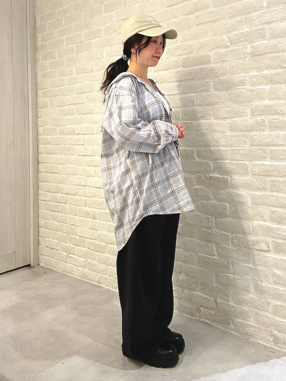 ブルー系のシャツ/ブラウス、ブラック系のスラックス、ホワイト系のトートバッグを着用したレディースの春コーディネートの3枚目の写真