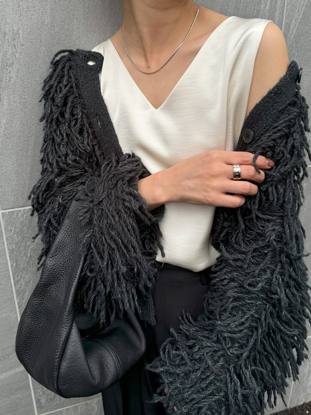 グレー系のカーディガン/ボレロ、ホワイト系のタンクトップ、ブラック系のスラックスを着用したレディースの秋コーディネートの2枚目の写真