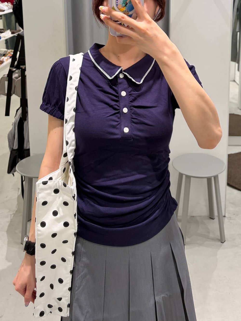 ブラック系のローファー、グレー系のスカート、ホワイト系のトートバッグを着用したレディースの夏コーディネートの3枚目の写真