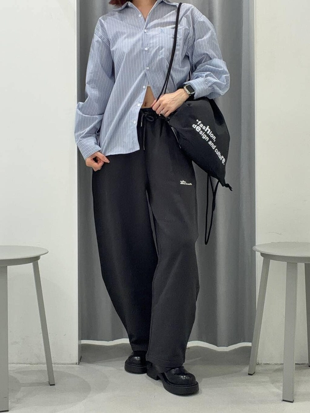 ブラック系のバックパック/リュック、ブルー系のシャツ/ブラウス、ブラック系のスウェットパンツを着用したレディースの冬コーディネートの3枚目の写真