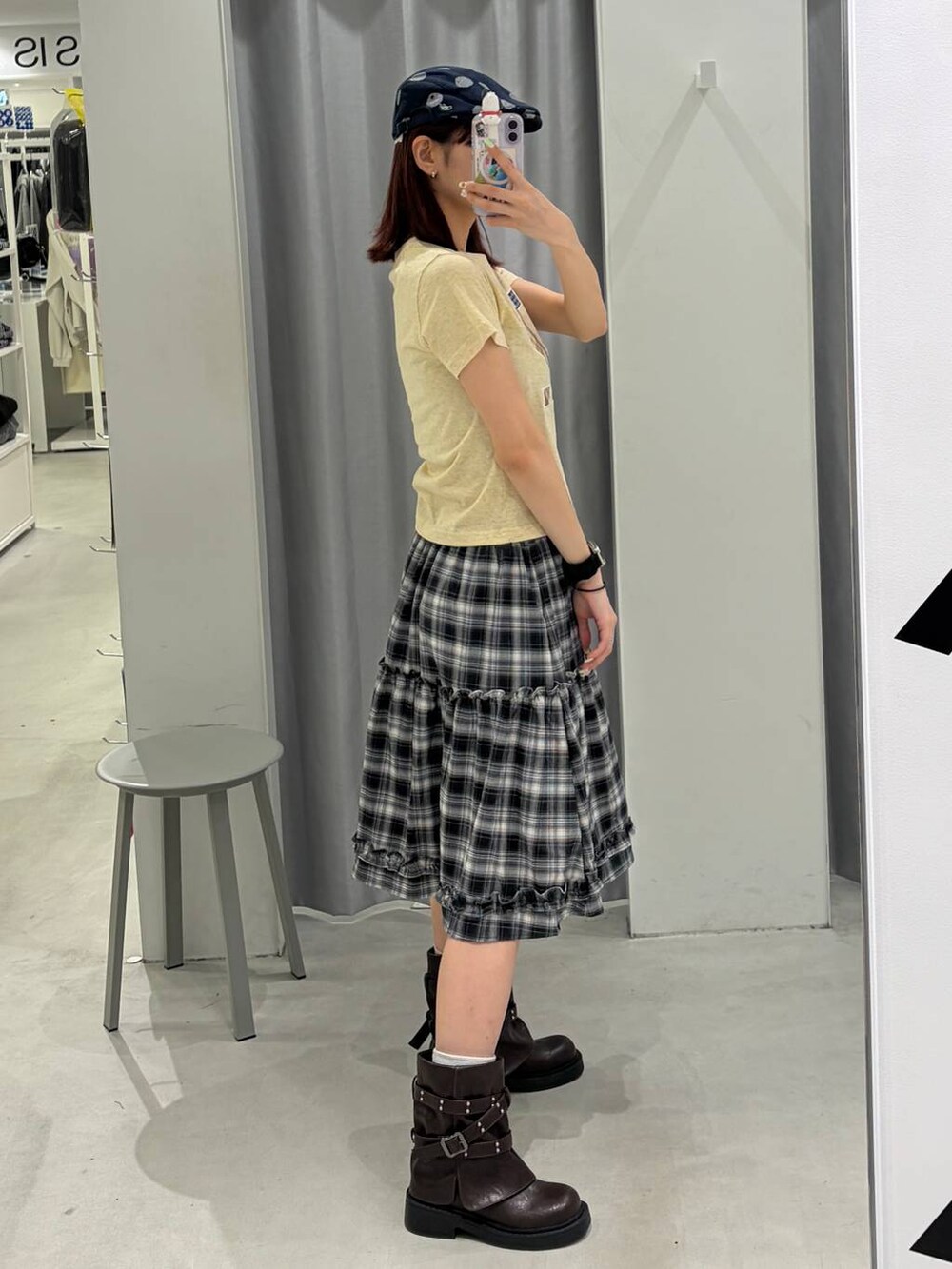 ブラウン系のブーツ、ホワイト系のスカート、イエロー系のTシャツ/カットソーを着用したレディースの春コーディネートの3枚目の写真