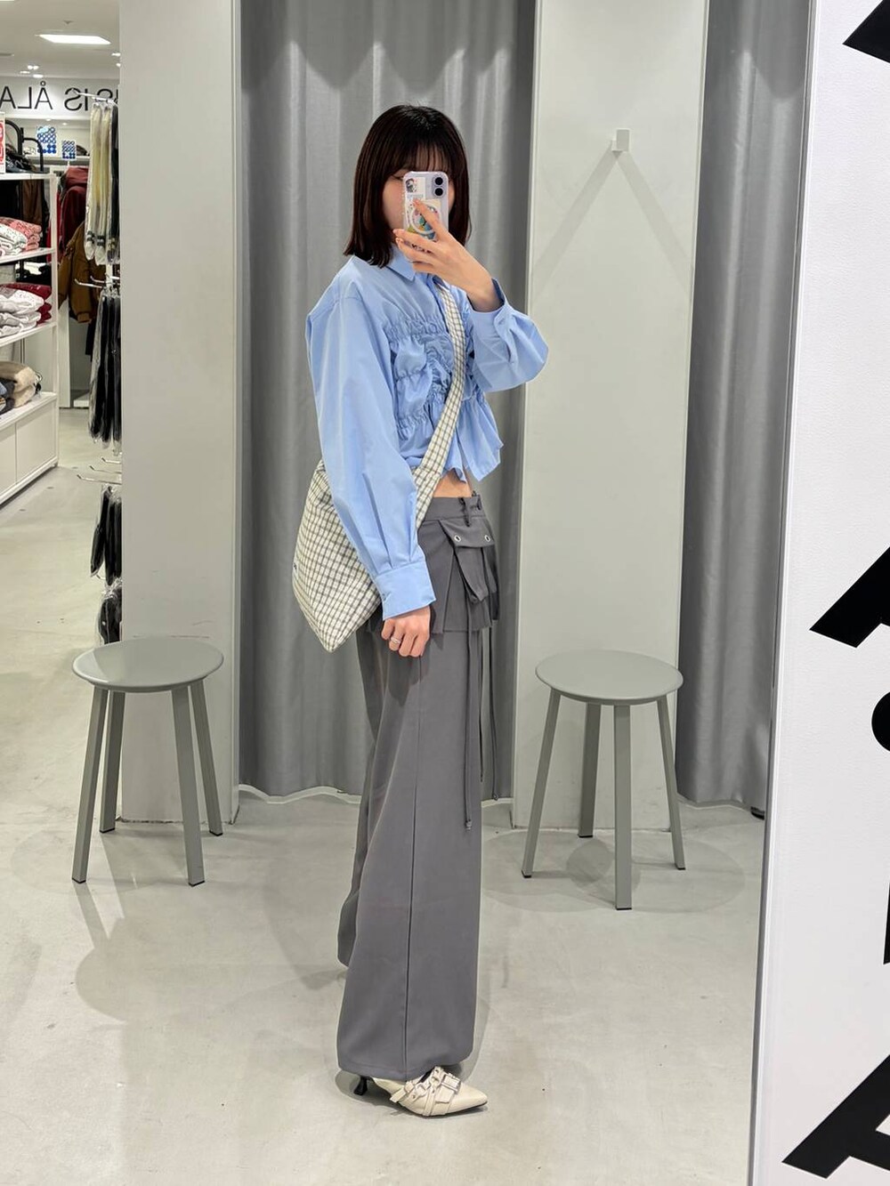 その他のトートバッグ、ホワイト系のパンプス、グレー系のスラックスを着用したレディースの冬コーディネートの2枚目の写真