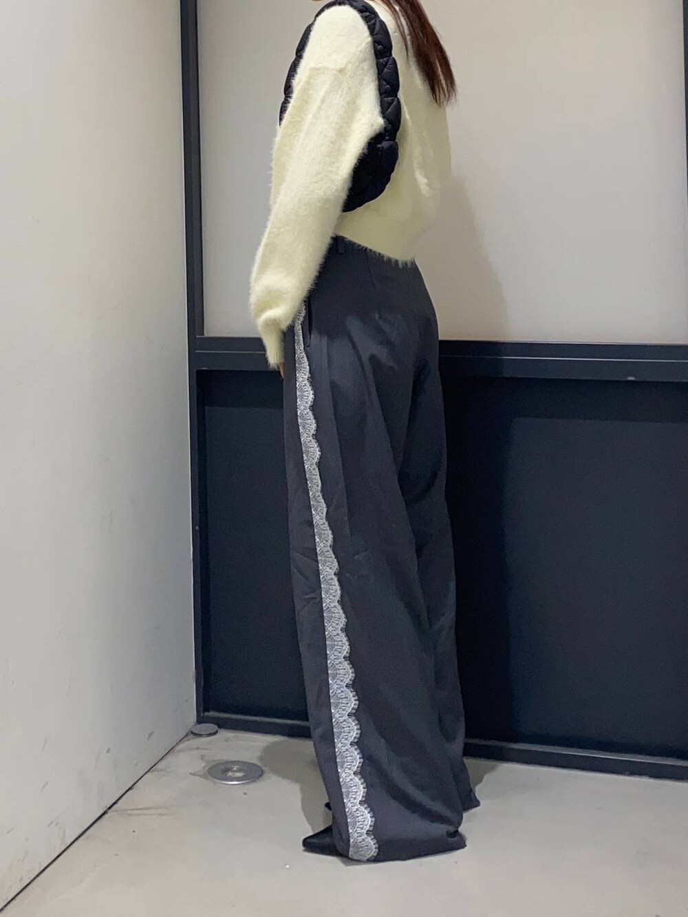 ブラック系のサンダル、ブラック系のショルダーバッグ、グレー系のスラックスを着用したレディースの秋コーディネートの2枚目の写真