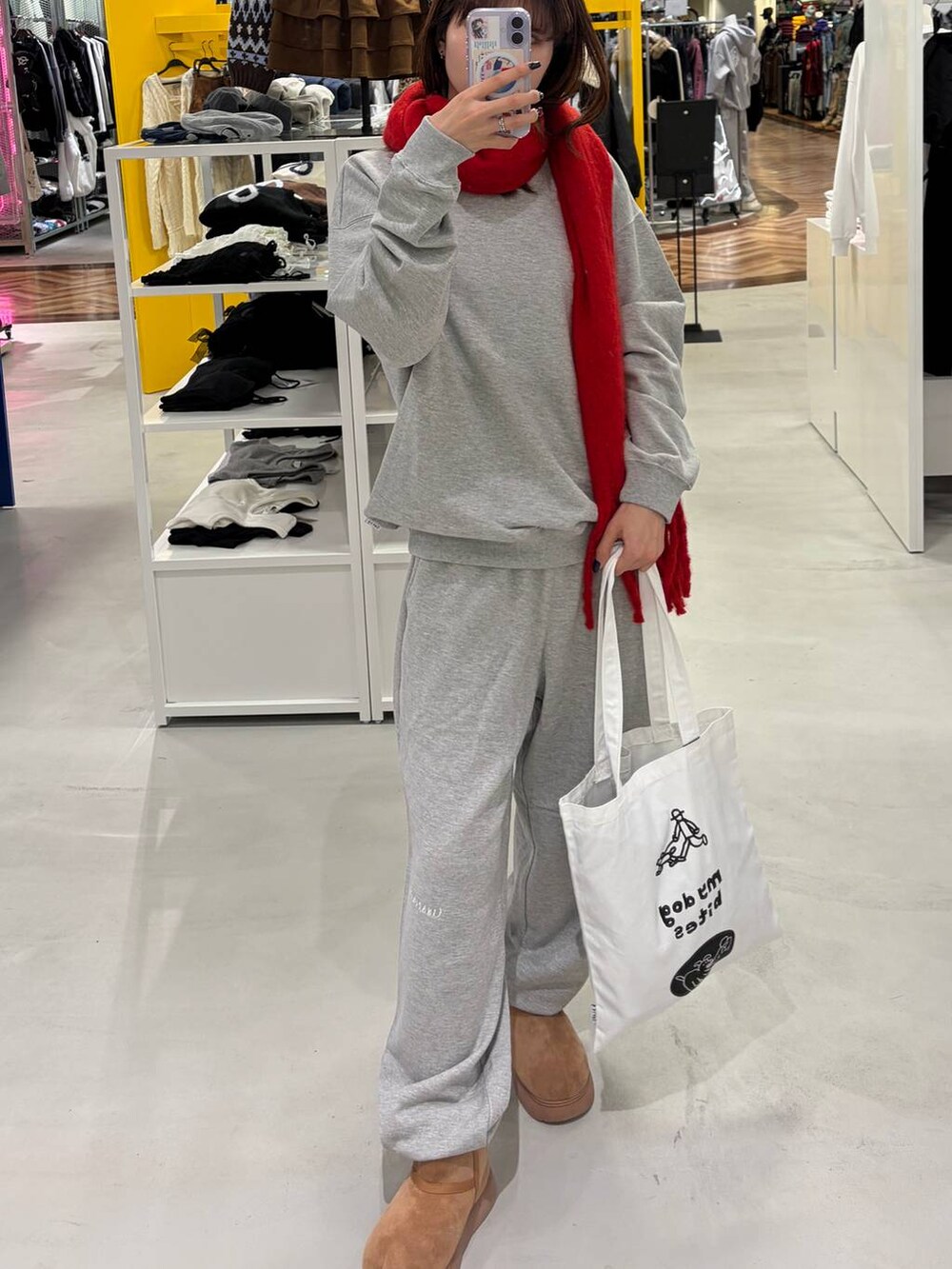 イエロー系のブーツ、ホワイト系のトートバッグ、グレー系のその他パンツを着用したレディースの秋コーディネートの2枚目の写真