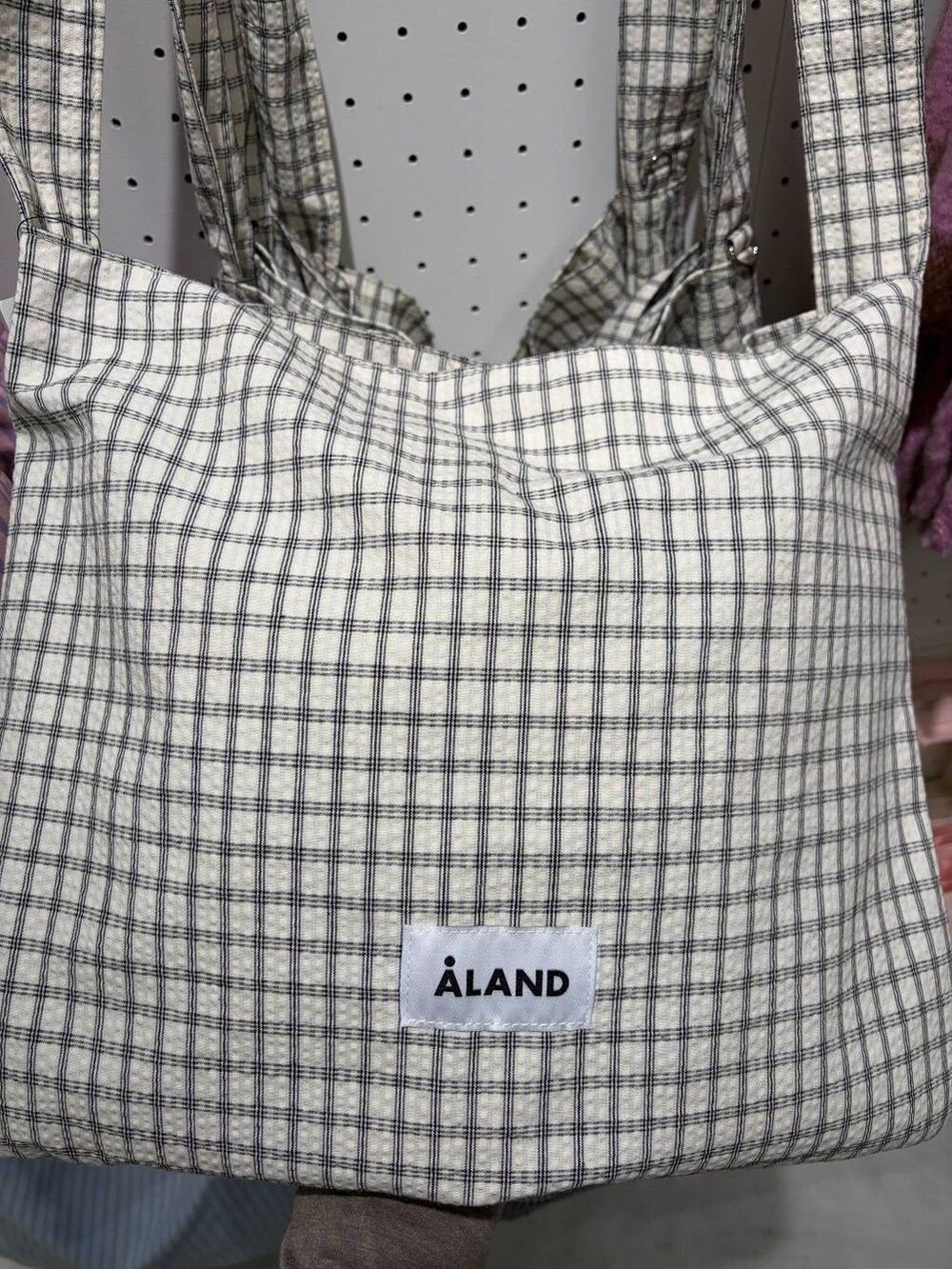 その他のトートバッグ、ホワイト系のパンプス、グレー系のスラックスを着用したレディースの冬コーディネートの4枚目の写真