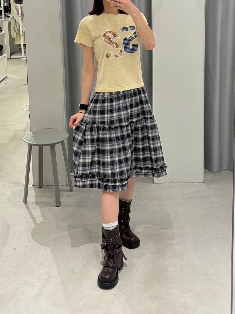 ブラウン系のブーツ、ホワイト系のスカート、イエロー系のTシャツ/カットソーを着用したレディースの春コーディネートの4枚目の写真