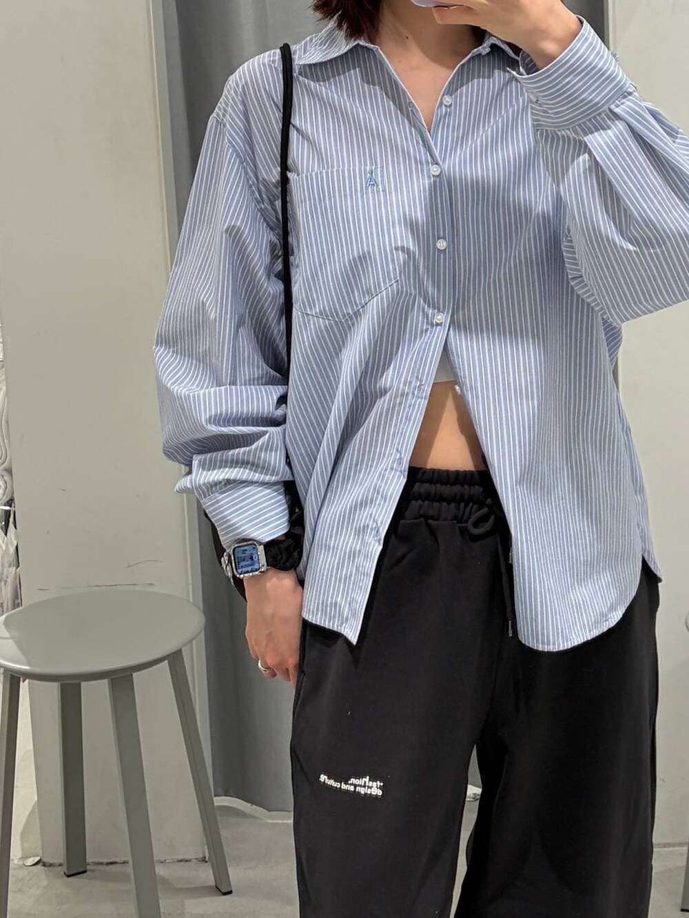 ブラック系のバックパック/リュック、ブルー系のシャツ/ブラウス、ブラック系のスウェットパンツを着用したレディースの冬コーディネートの2枚目の写真