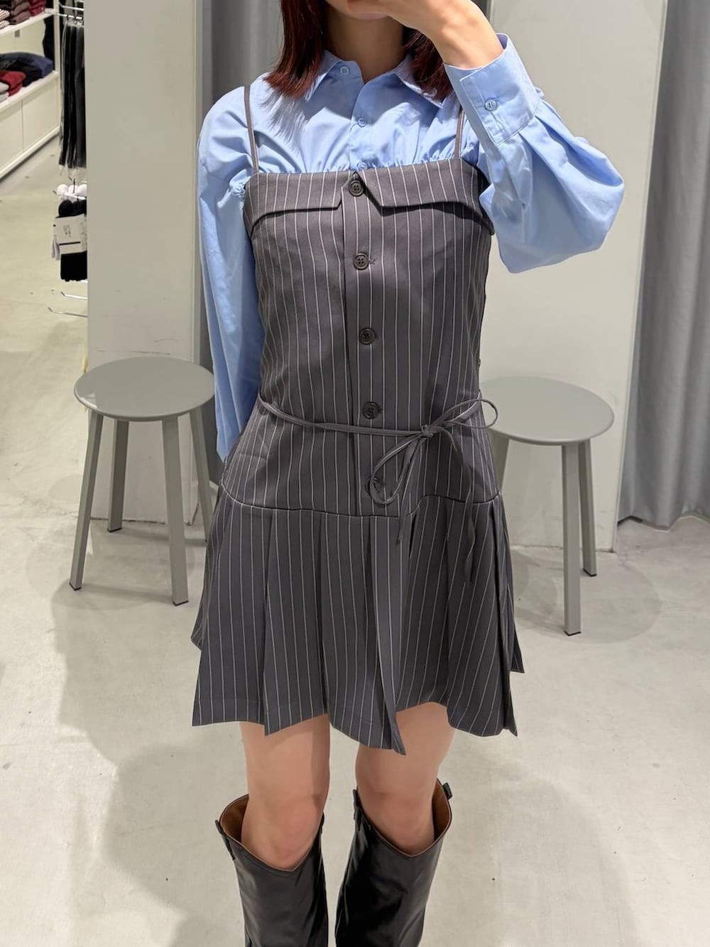 ブルー系のシャツ/ブラウス、ブラック系のブーツ、グレー系のワンピースを着用したレディースの春コーディネートの2枚目の写真