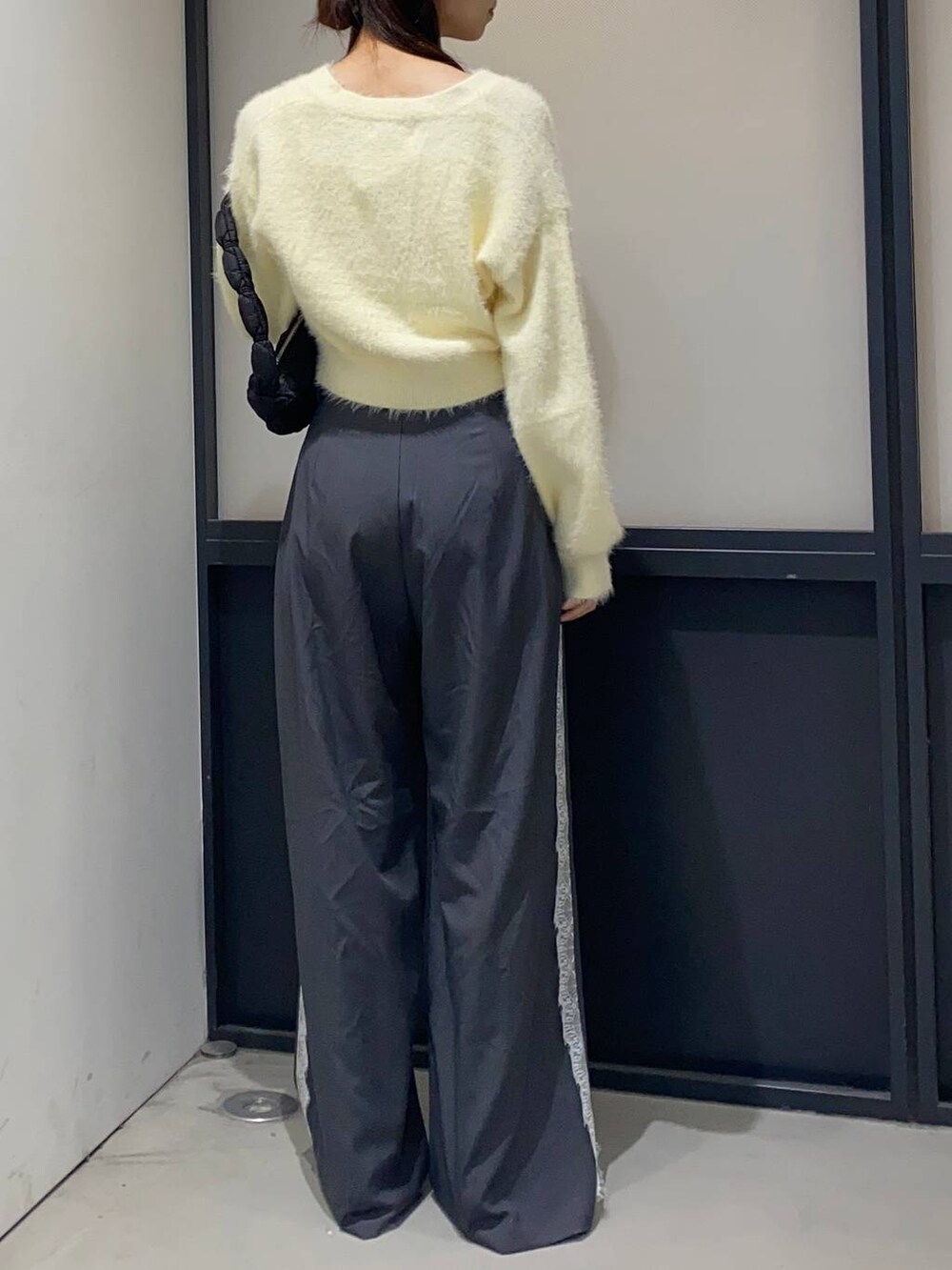 ブラック系のサンダル、ブラック系のショルダーバッグ、グレー系のスラックスを着用したレディースの秋コーディネートの3枚目の写真