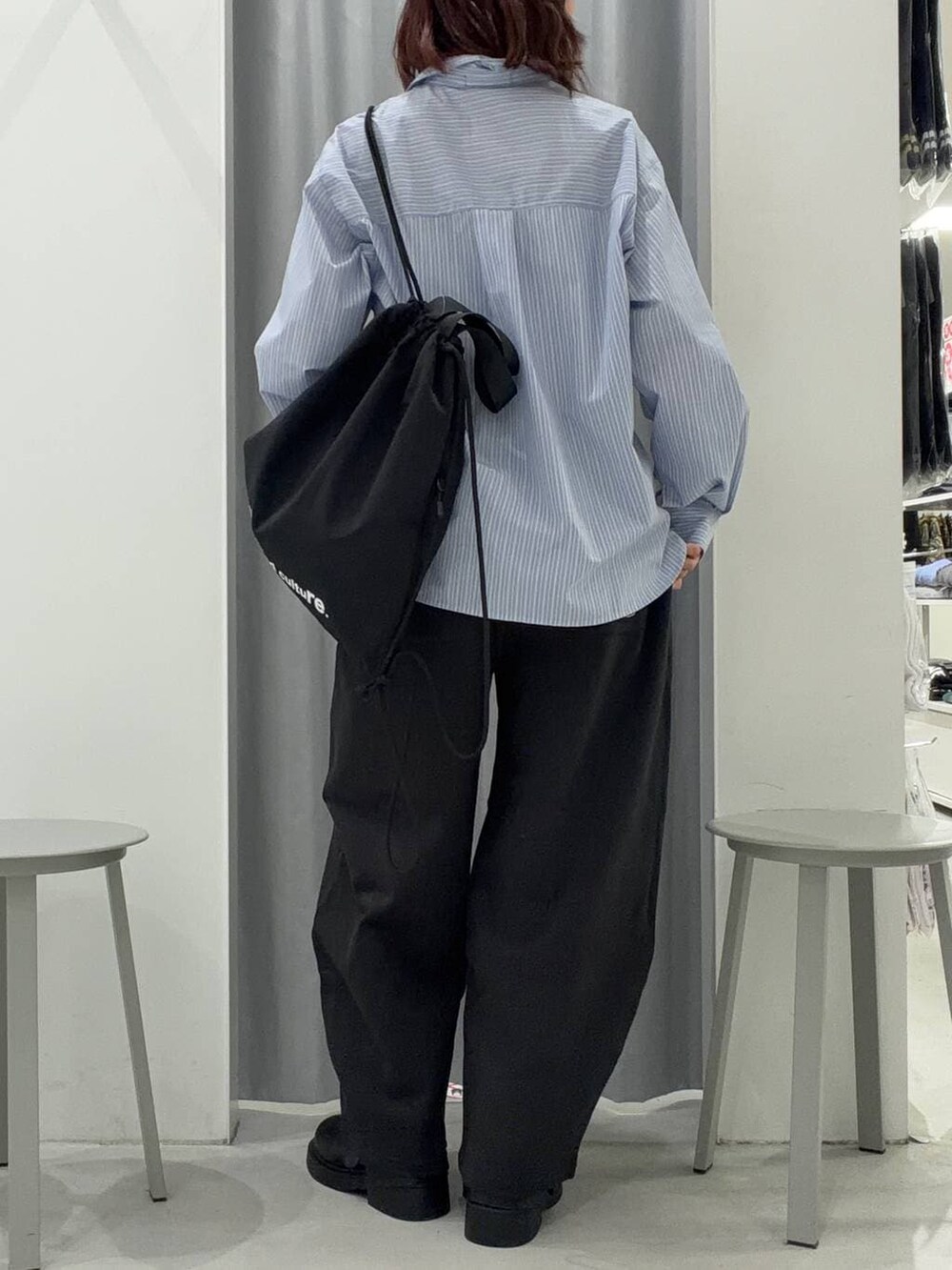 ブラック系のバックパック/リュック、ブルー系のシャツ/ブラウス、ブラック系のスウェットパンツを着用したレディースの冬コーディネートの4枚目の写真