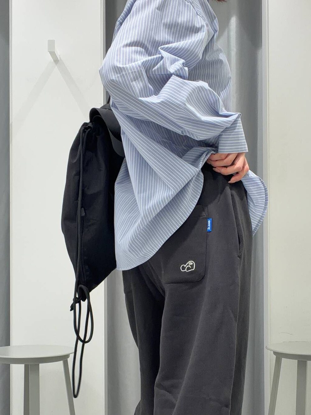 ブラック系のバックパック/リュック、ブルー系のシャツ/ブラウス、ブラック系のスウェットパンツを着用したレディースの冬コーディネートの5枚目の写真