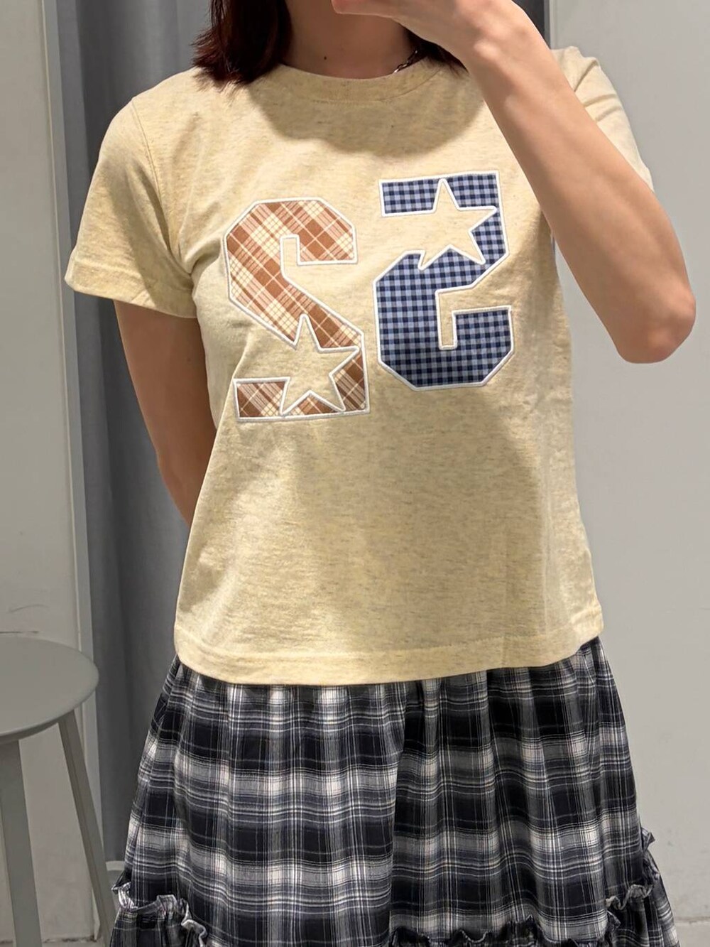 ブラウン系のブーツ、ホワイト系のスカート、イエロー系のTシャツ/カットソーを着用したレディースの春コーディネートの2枚目の写真