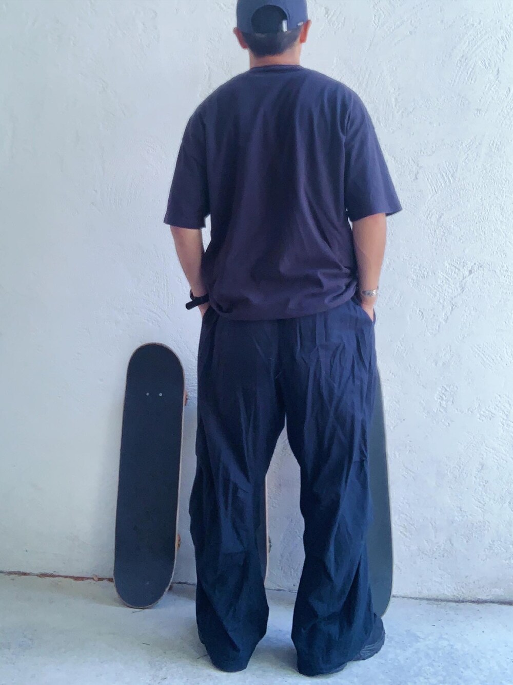 ブラック系のTシャツ/カットソー、ブルー系のパンツ、ブラック系のスニーカーを着用したメンズの夏コーディネートの2枚目の写真