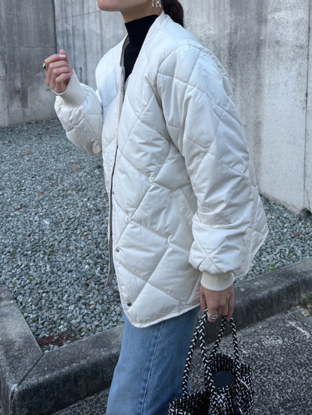 ホワイト系のノーカラージャケットを着用したレディースの冬コーディネートの3枚目の写真