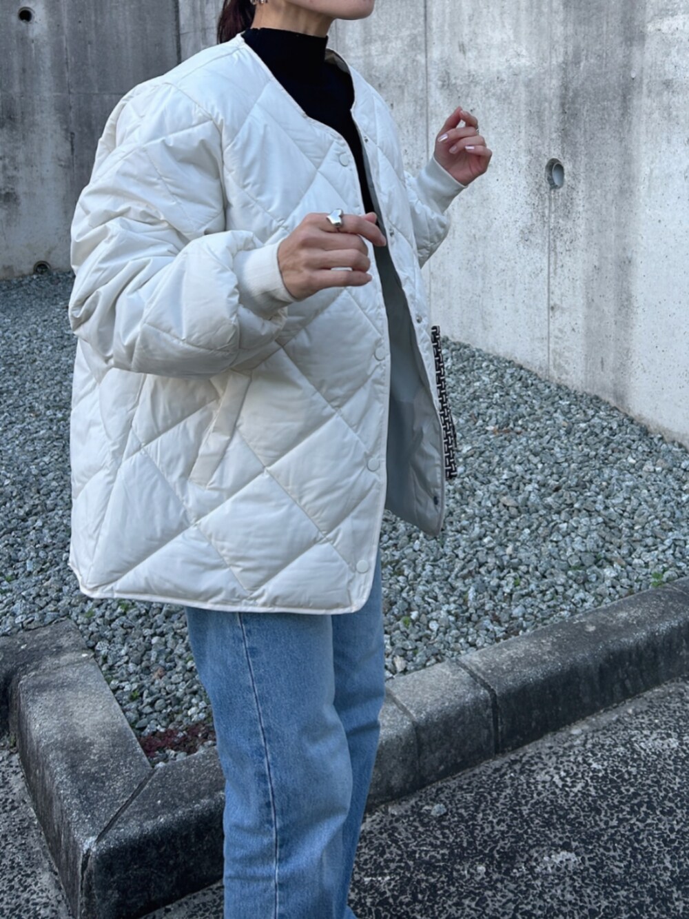 ホワイト系のノーカラージャケットを着用したレディースの冬コーディネートの2枚目の写真