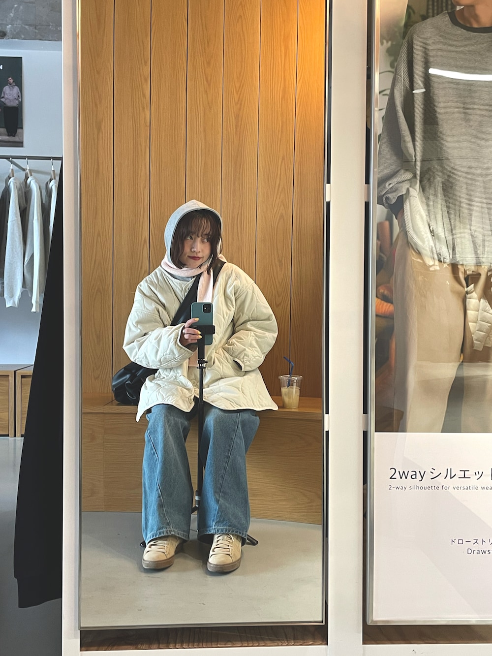 ベージュ系のスニーカー、ホワイト系のブルゾン、ブラック系のショルダーバッグを着用したレディースの春コーディネートの3枚目の写真