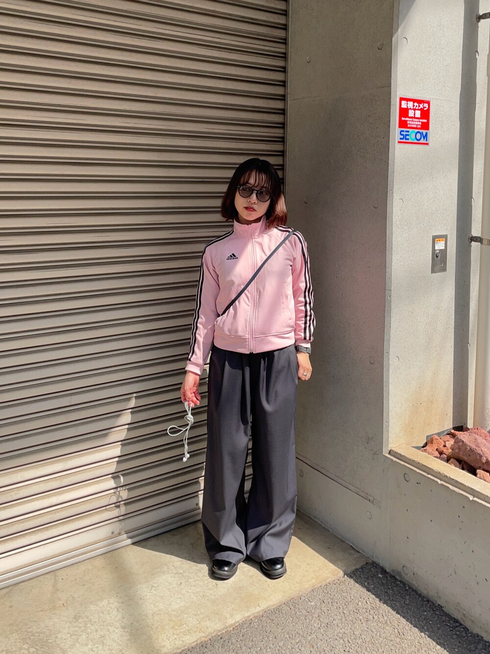 ピンク系のジャケット/アウター、ブラック系のその他シューズ、ブラック系のサングラスを着用したレディースの春コーディネートの2枚目の写真