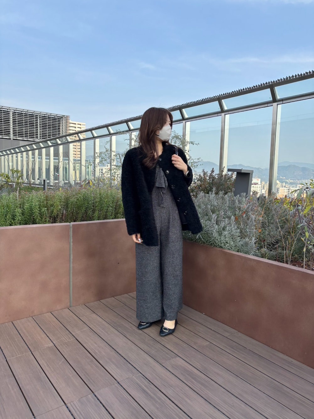 ブラック系のノーカラージャケット、ブラック系のサロペット/オーバーオール、ブラック系のショルダーバッグを着用したレディースの冬コーディネートの3枚目の写真