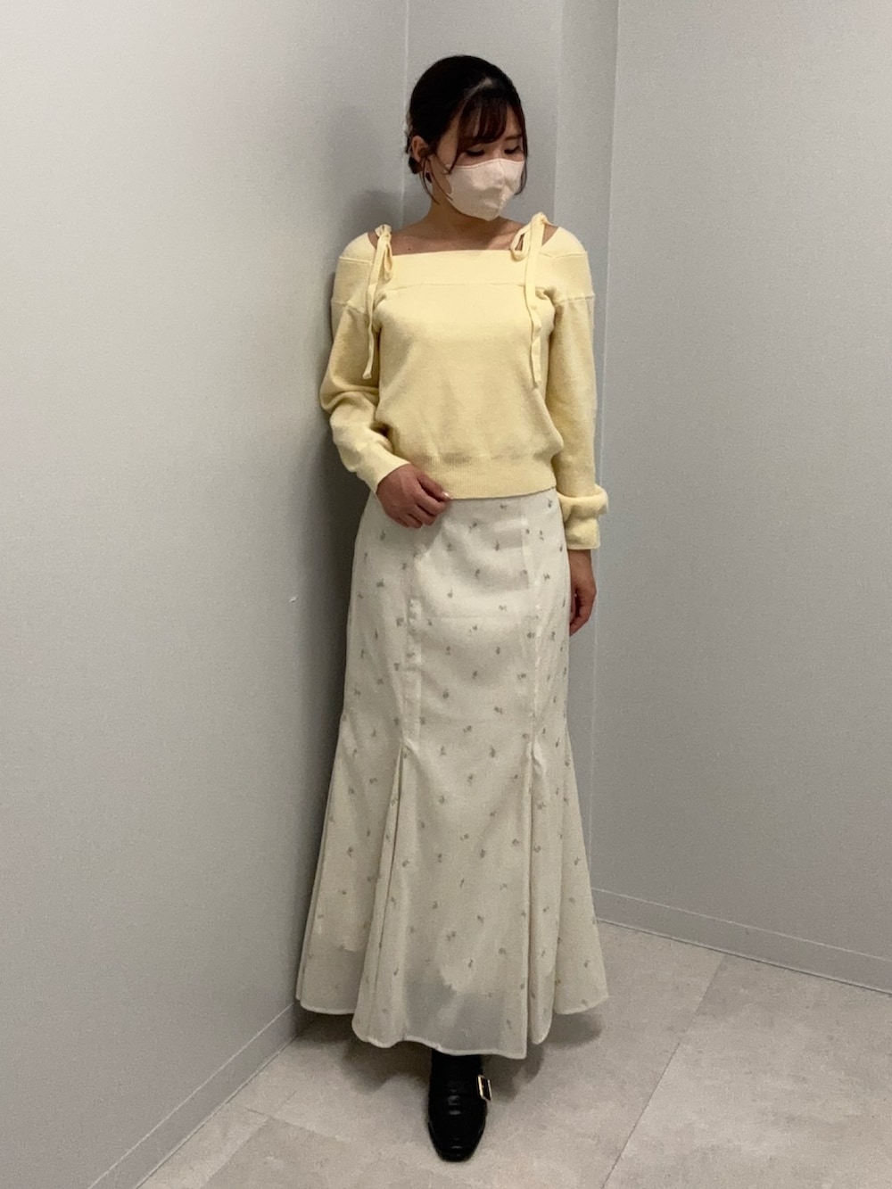 ホワイト系のスカート、イエロー系のニット/セーター、ベージュ系のブルゾンを着用したレディースの冬コーディネートの2枚目の写真