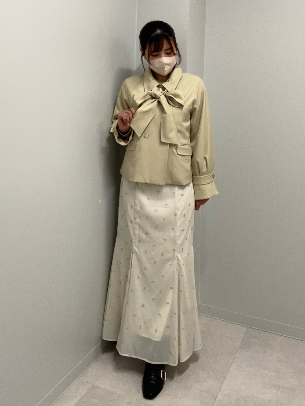 ホワイト系のスカート、イエロー系のニット/セーター、ベージュ系のブルゾンを着用したレディースの冬コーディネートの3枚目の写真