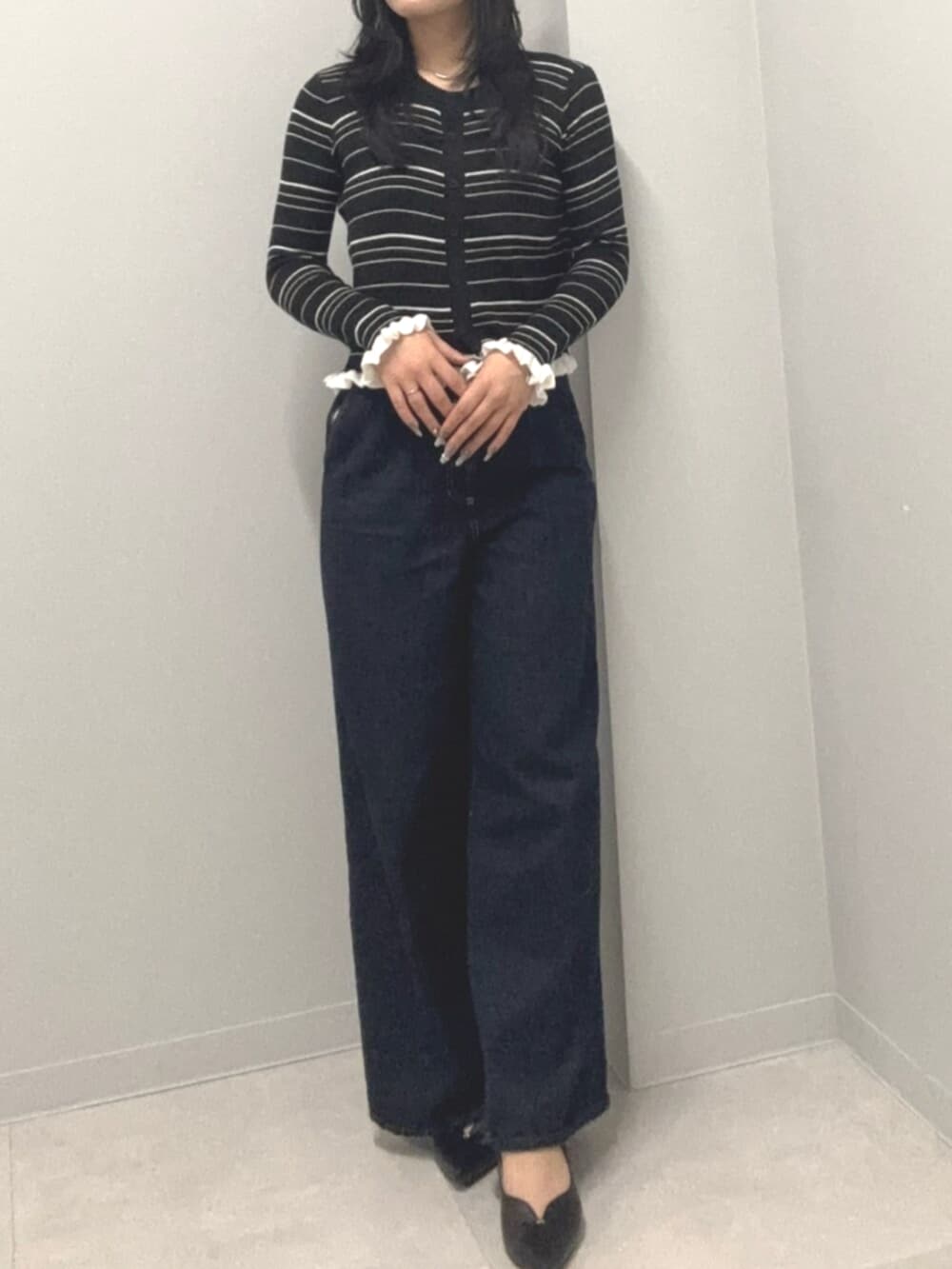 ブルー系のデニムパンツ、ブラック系のカーディガン/ボレロを着用したレディースの春コーディネートの2枚目の写真