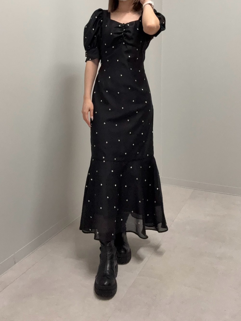 ブラック系のワンピース、ブラック系のブーツを着用したレディースの春コーディネートの2枚目の写真