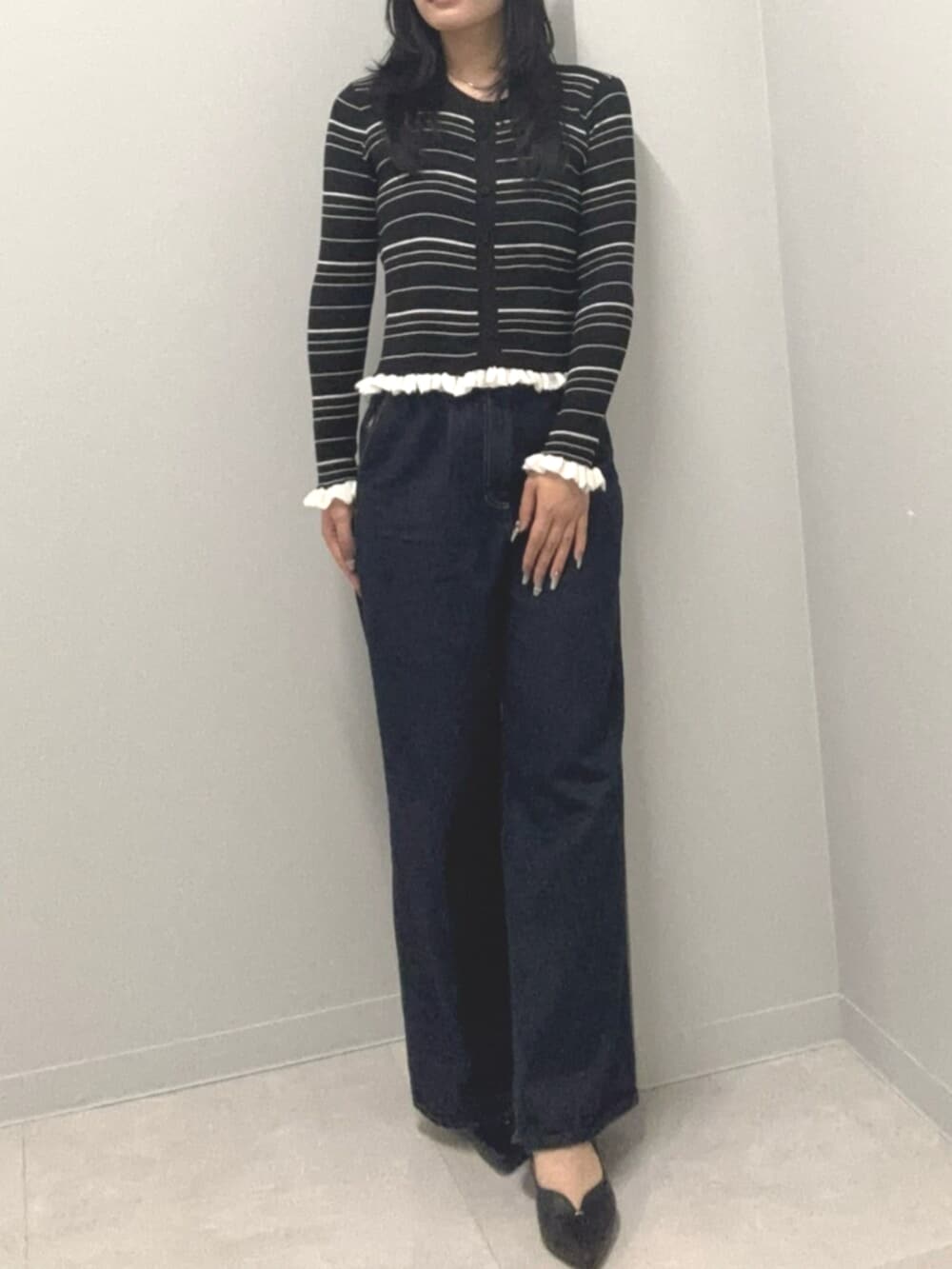 ブルー系のデニムパンツ、ブラック系のカーディガン/ボレロを着用したレディースの春コーディネートの3枚目の写真