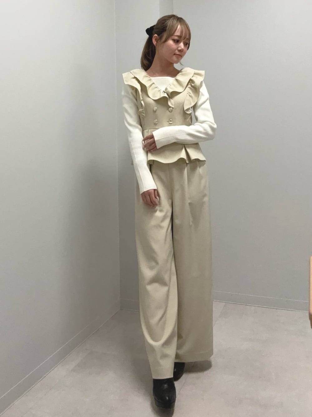 ホワイト系のニット/セーター、ベージュ系のつなぎ/オールインワン、ブラック系のブーツを着用したレディースの冬コーディネートの2枚目の写真