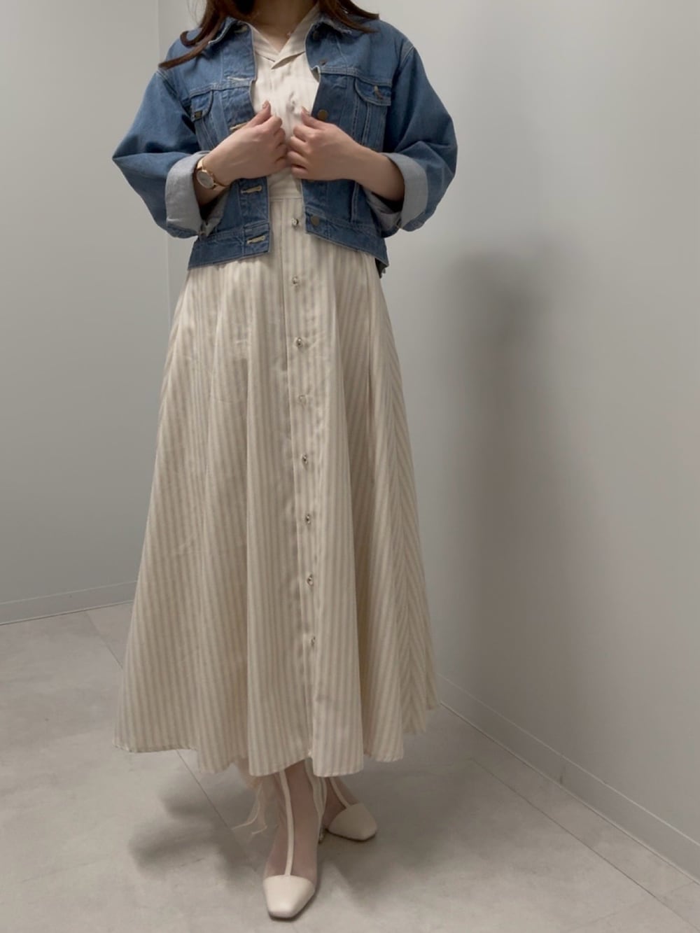 ブルー系のデニムジャケット、ベージュ系のワンピース、ベージュ系のブーツを着用したレディースの春コーディネートの2枚目の写真