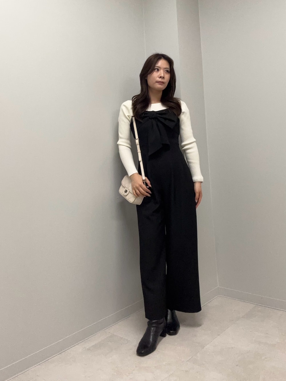 ブラック系のつなぎ/オールインワン、ホワイト系のニット/セーターを着用したレディースの春コーディネートの3枚目の写真