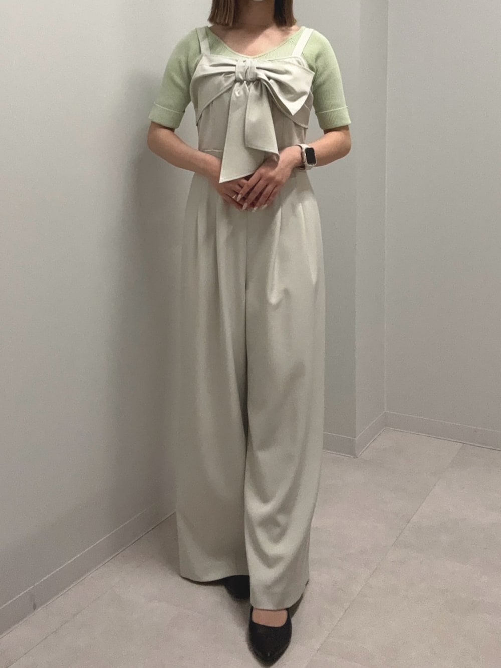 ベージュ系のつなぎ/オールインワン、グリーン系のニット/セーター、ブラック系のパンプスを着用したレディースの春コーディネートの2枚目の写真