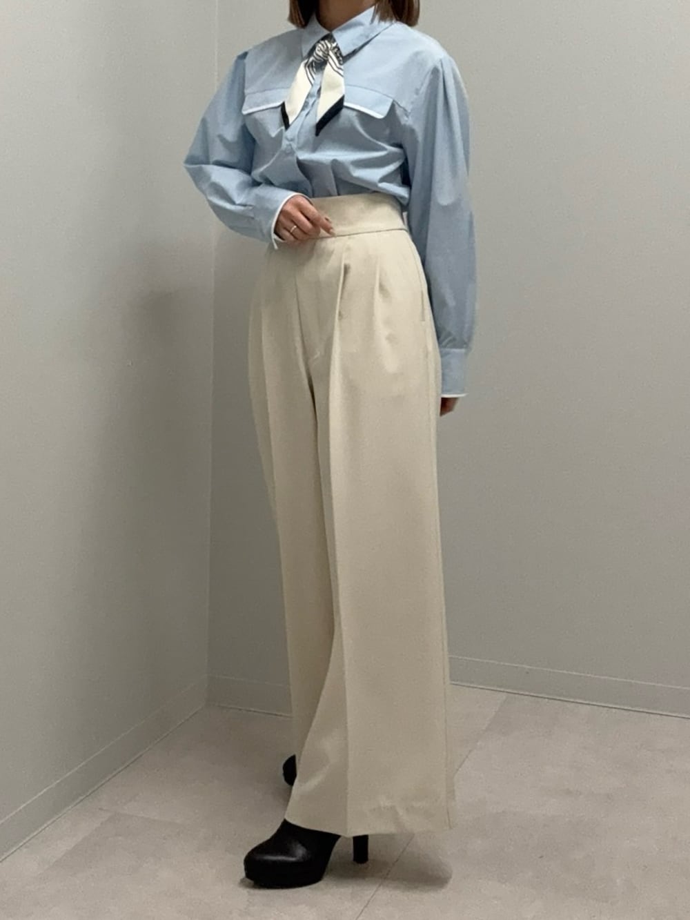 ブルー系のシャツ/ブラウス、ベージュ系のその他パンツ、ブラック系のブーツを着用したレディースの春コーディネートの2枚目の写真