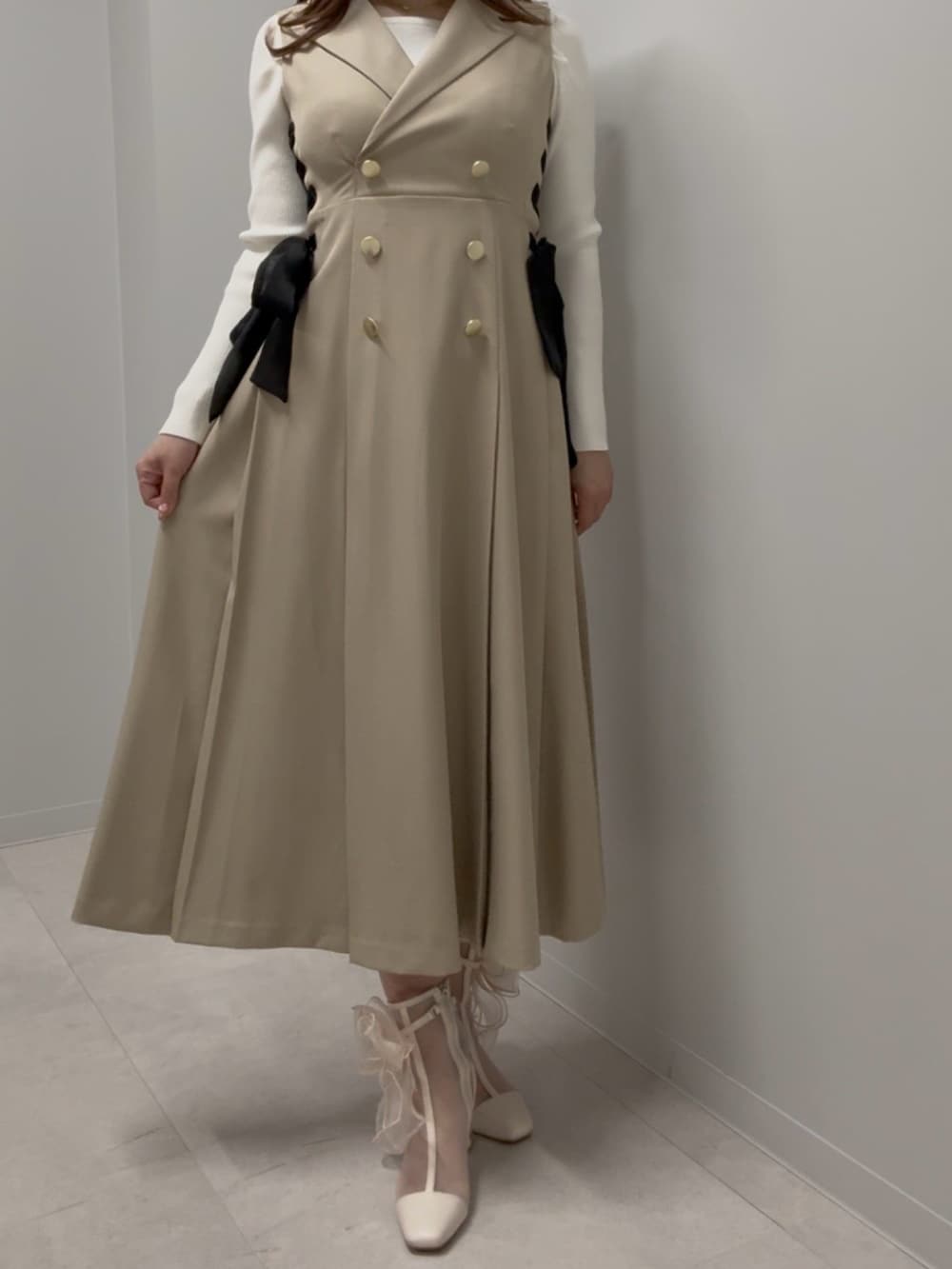 ホワイト系のニット/セーター、ベージュ系のワンピース、ベージュ系のブーツを着用したレディースの春コーディネートの2枚目の写真