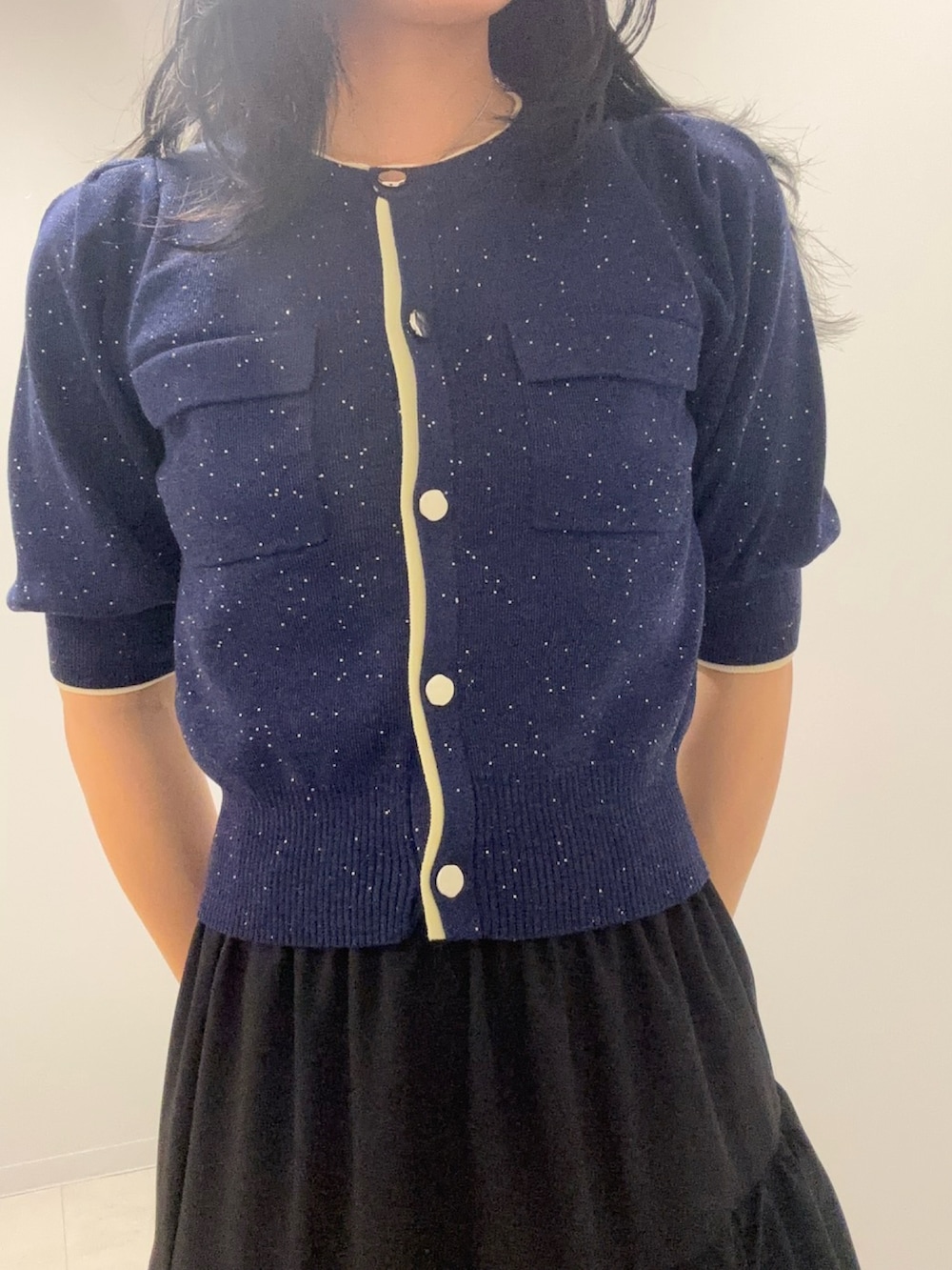 ブルー系のカーディガン/ボレロ、ブラック系のスカートを着用したレディースの春コーディネートの5枚目の写真