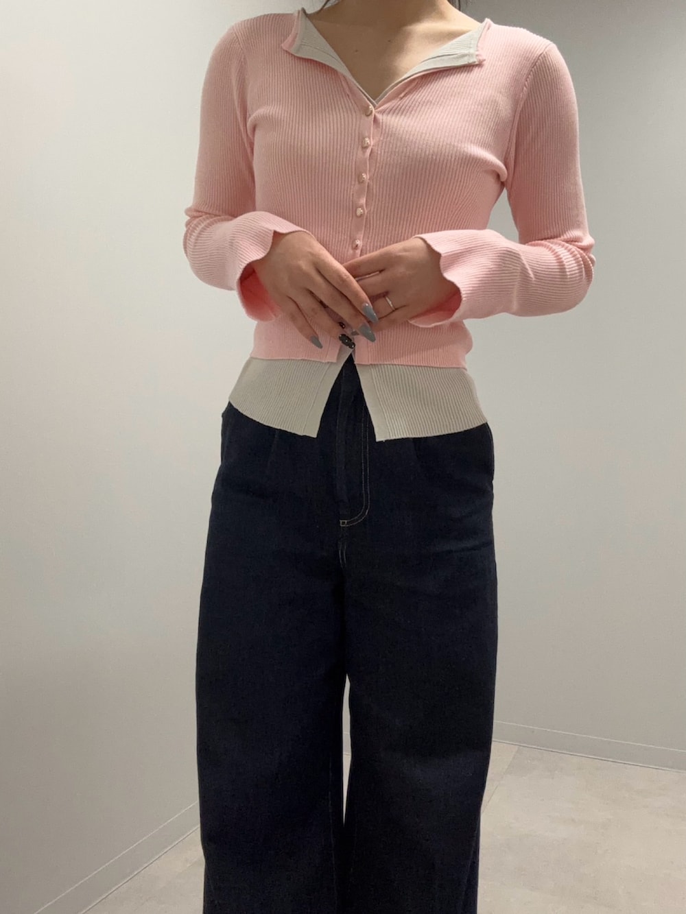 ピンク系のニット/セーター、ブルー系のデニムパンツを着用したレディースの春コーディネートの3枚目の写真