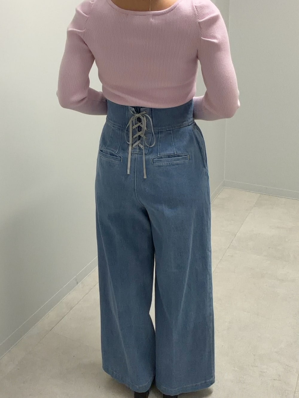 ピンク系のニット/セーター、ブルー系のデニムパンツを着用したレディースの春コーディネートの2枚目の写真