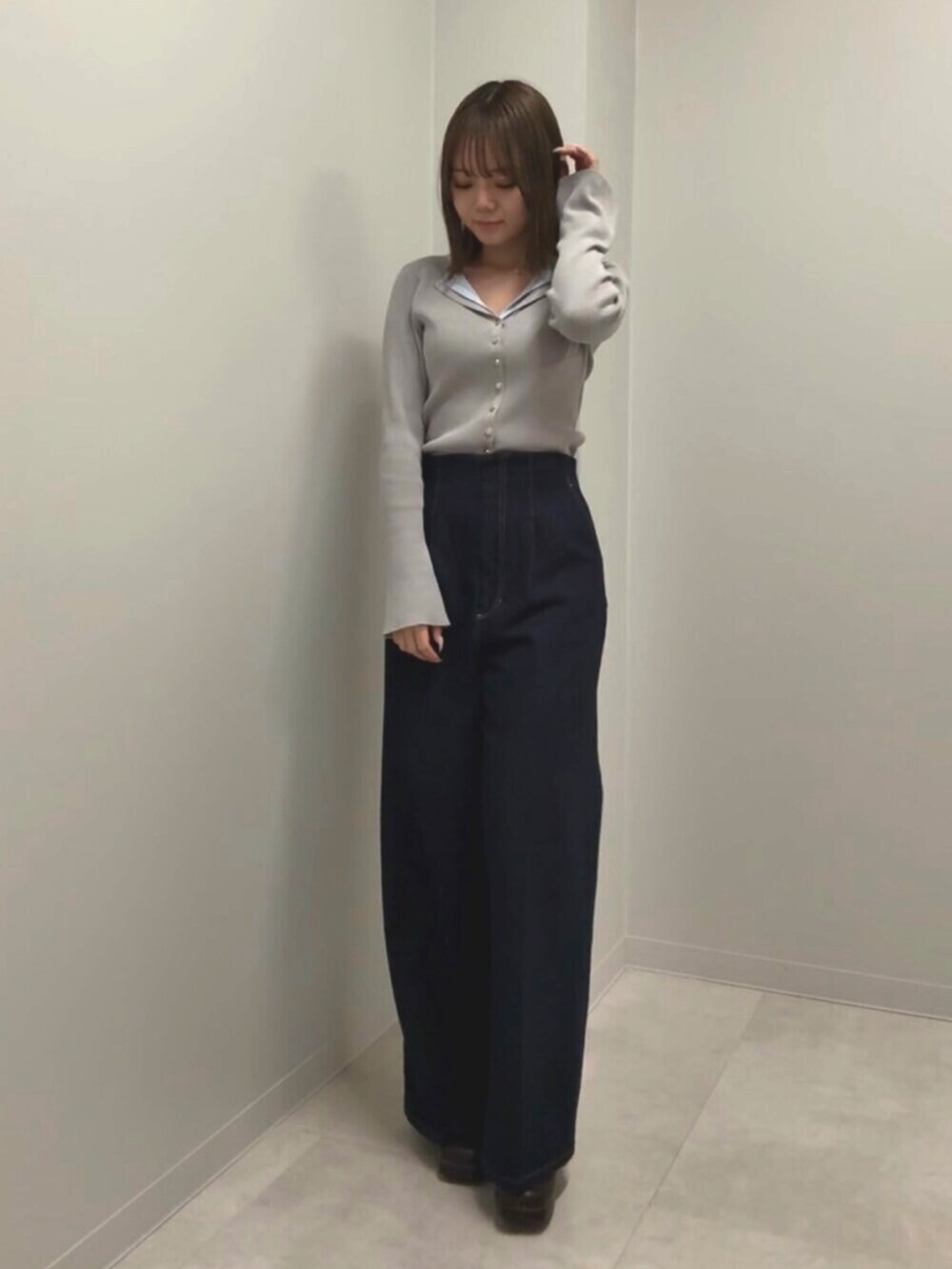 ブルー系のデニムパンツ、グレー系のニット/セーターを着用したレディースの春コーディネートの4枚目の写真