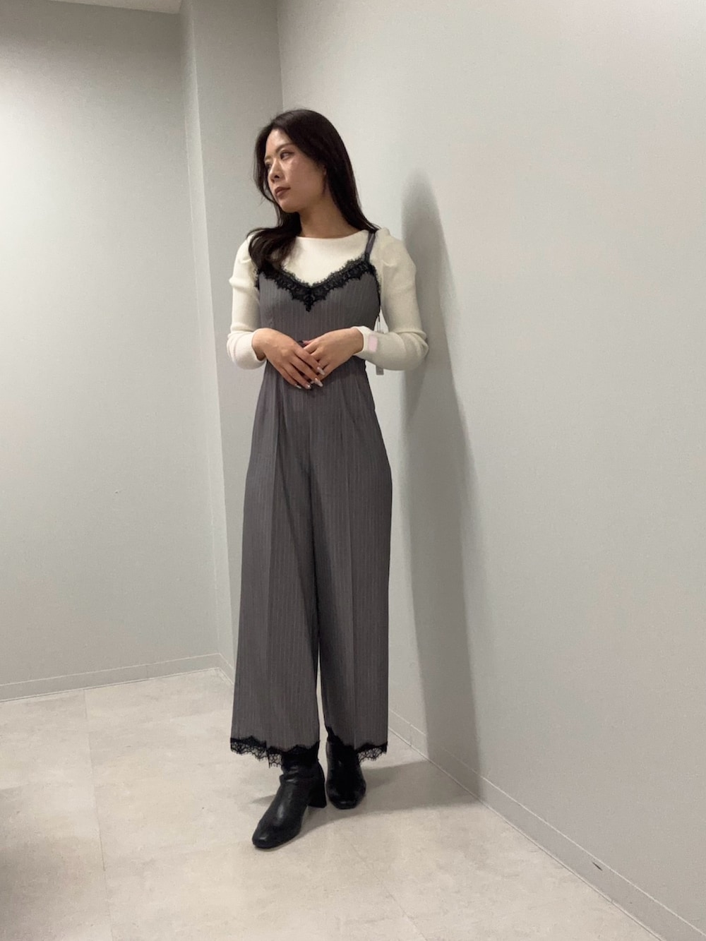 グレー系のつなぎ/オールインワン、ホワイト系のニット/セーターを着用したレディースの春コーディネートの2枚目の写真