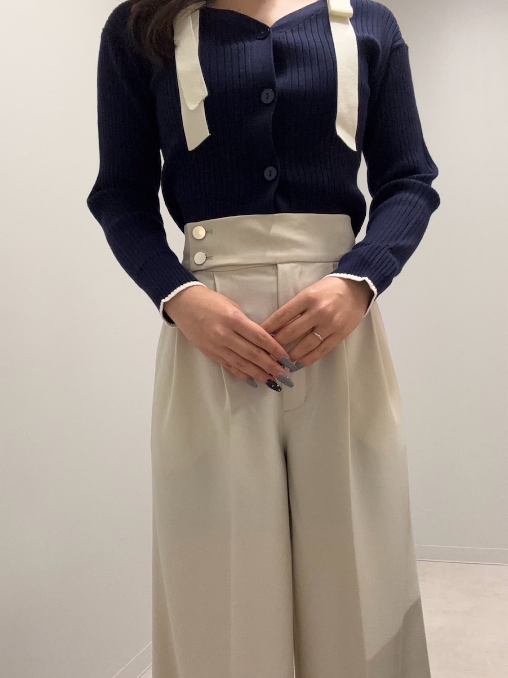 ブルー系のニット/セーター、ホワイト系のその他パンツを着用したレディースの春コーディネートの3枚目の写真