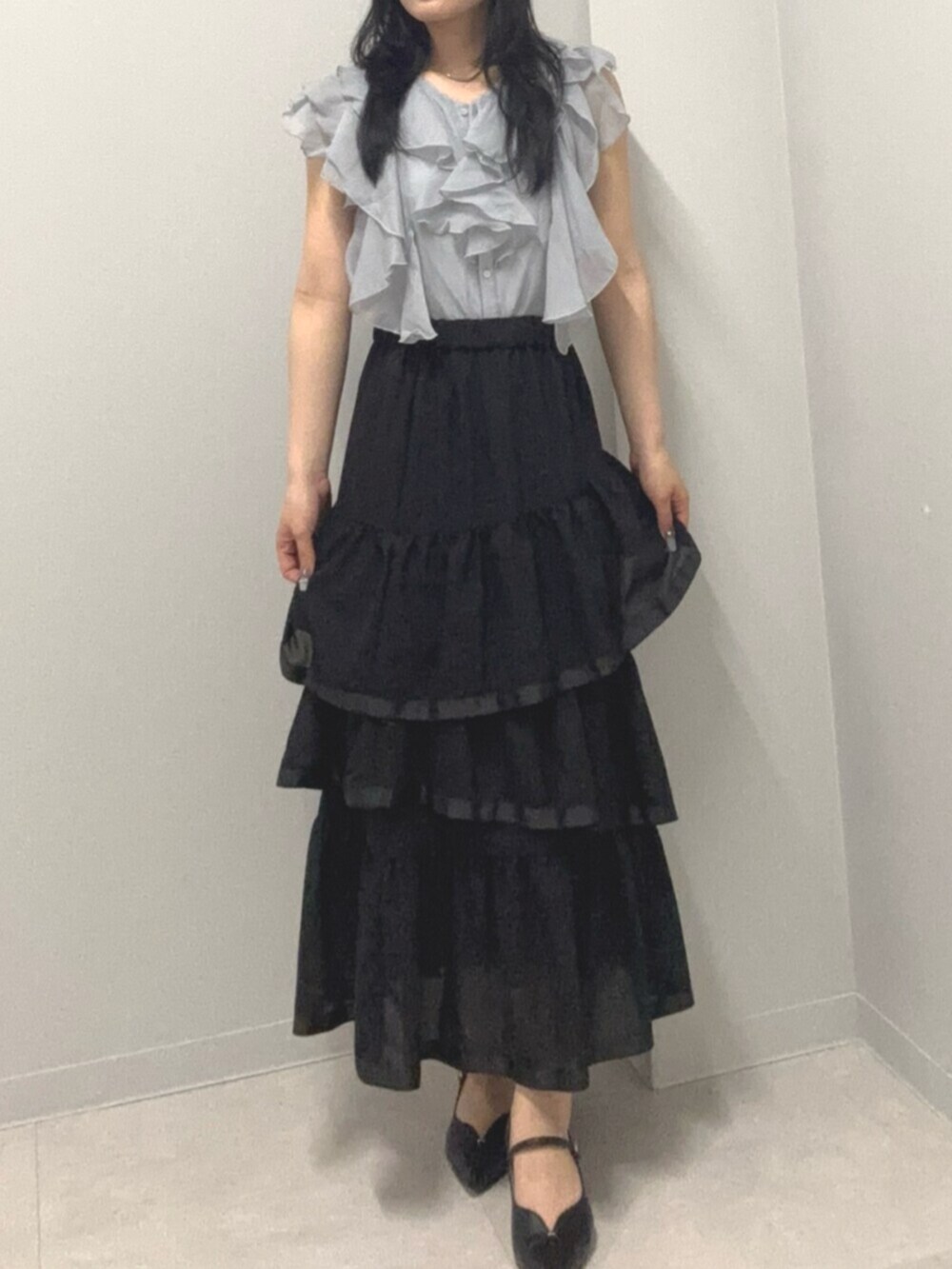 ブラック系のスカート、ブルー系のシャツ/ブラウスを着用したレディースの春コーディネートの2枚目の写真