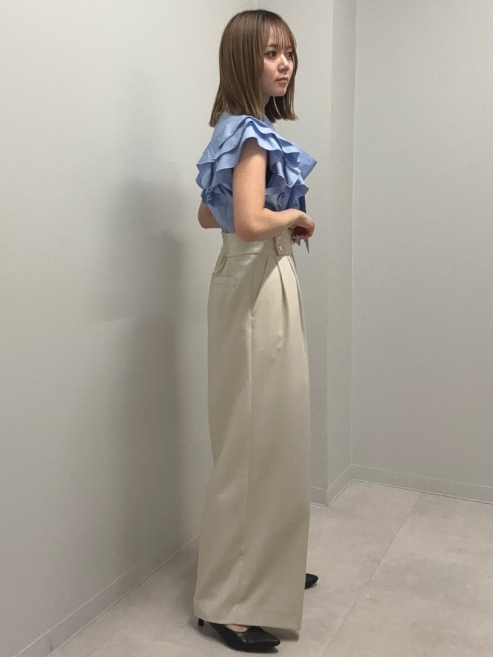 ブルー系のシャツ/ブラウス、ベージュ系のその他パンツ、ブラック系のパンプスを着用したレディースの春コーディネートの2枚目の写真