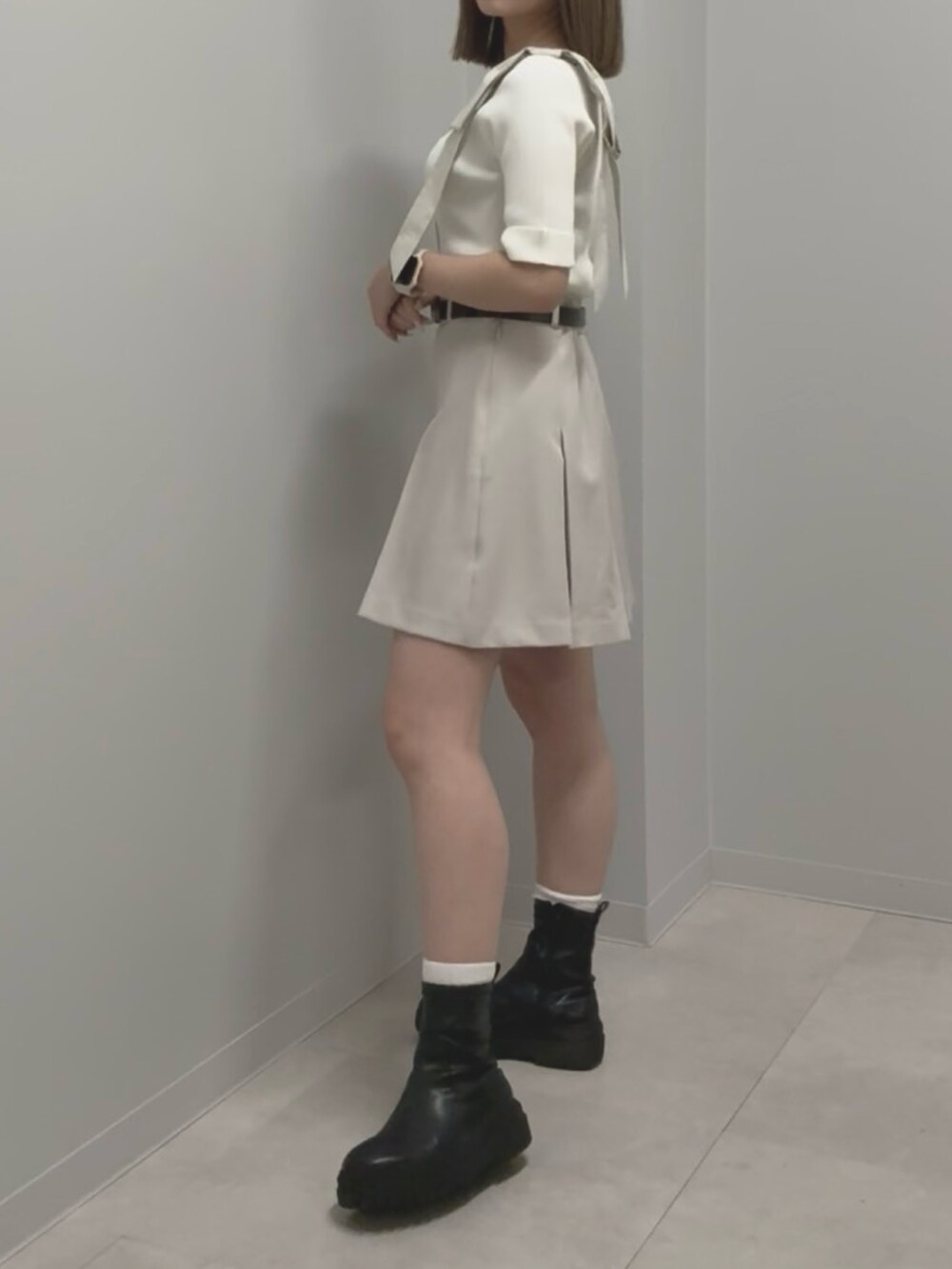 ホワイト系のニット/セーター、ベージュ系のその他パンツ、ブラック系のブーツを着用したレディースの春コーディネートの2枚目の写真