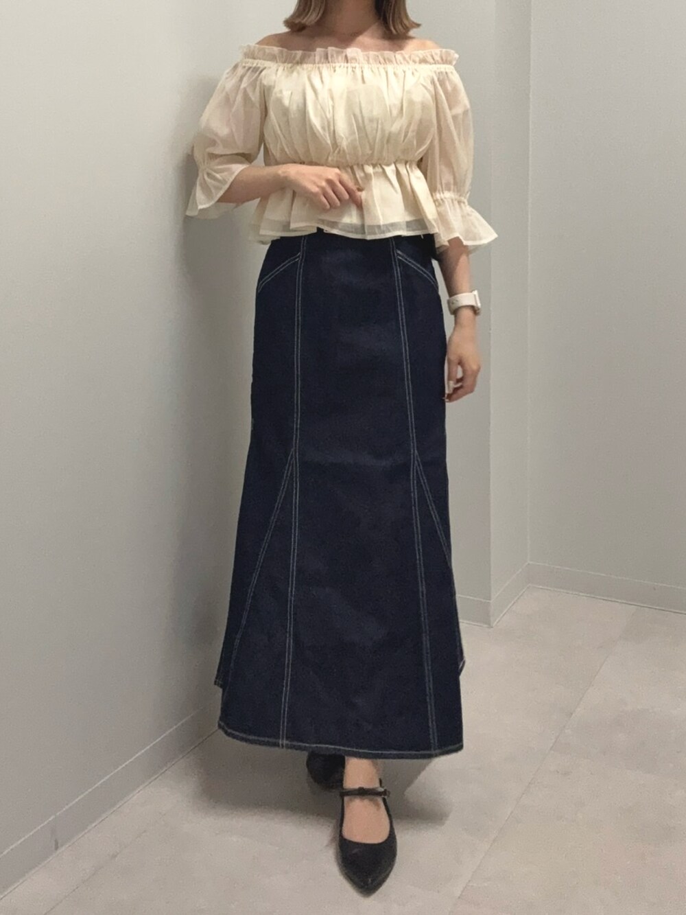 ベージュ系のシャツ/ブラウス、ブルー系のスカート、ブラック系のパンプスを着用したレディースの春コーディネートの2枚目の写真